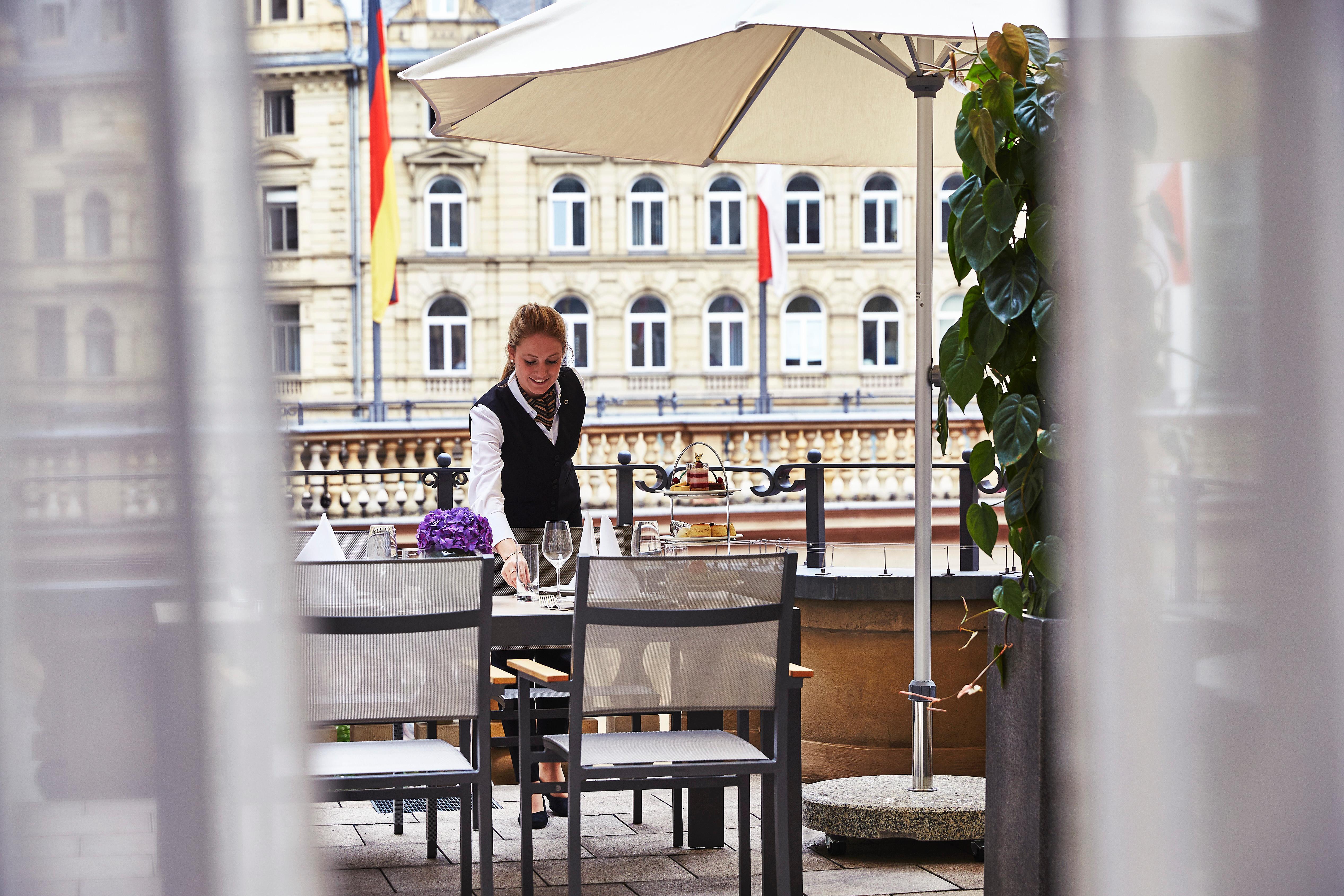 Steigenberger Icon Frankfurter Hof Hotel Frankfurt am Main Exterior photo A waitress clearing a table at a restaurant